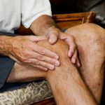 man massaging painful knee